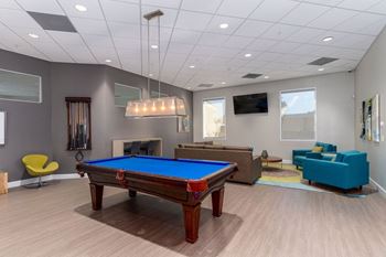 A room with a pool table and a fireplace.